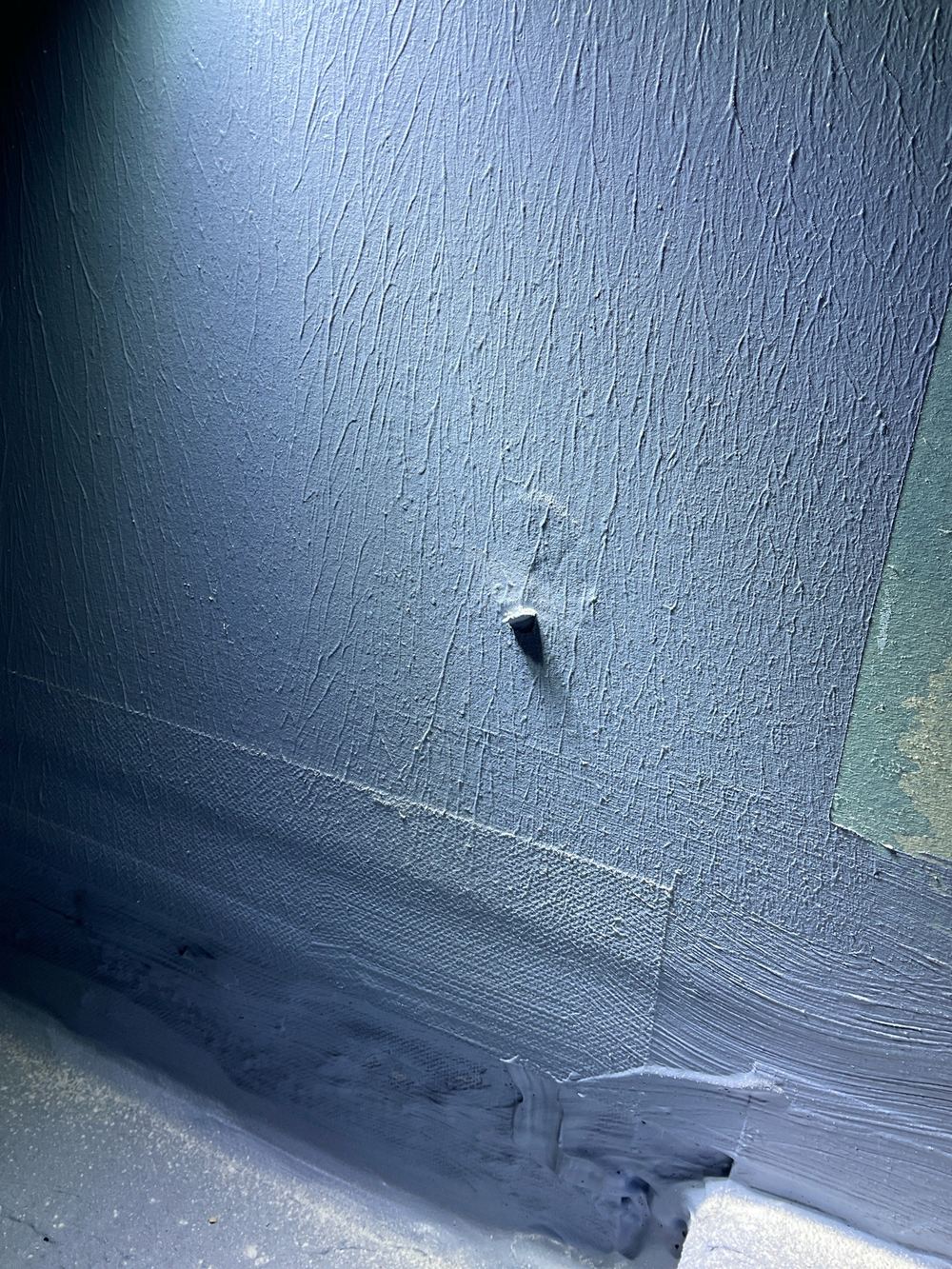 Damaged shower membrane that has to be repaired before tiling, found during a waterproofing inspection in Strathtulloh